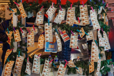 Thessaloniki, Greece street vendor selling Greek lottery payslips. Evening street view of hanging on clothespins Hellenic lotteries cards, called laxeia, for national lottery.のeditorial素材
