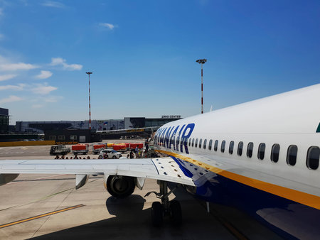 Passengers board on tarmac of Milan Bergamo airport, Italy. Day view of travelers at apron area of...