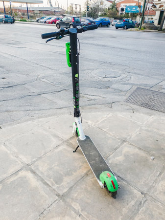 Parked Lime electric Scooter rental without passenger. A green and black ride sharing Lime-S electric scooter ready to be used by the next rider on the streets of Thessaloniki, Greece.のeditorial素材
