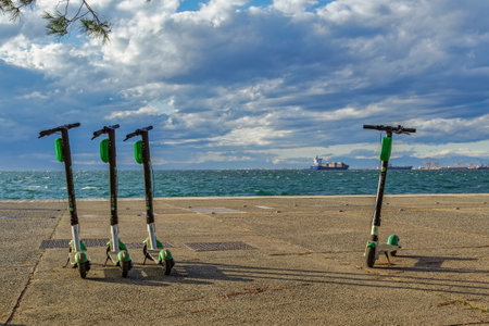 Thessaloniki, Greece Parked Lime Electric Scooter rentals without passenger. Green & black ride sharing Lime-S electric scooters at waterfront next to the sea, ready to be used.のeditorial素材