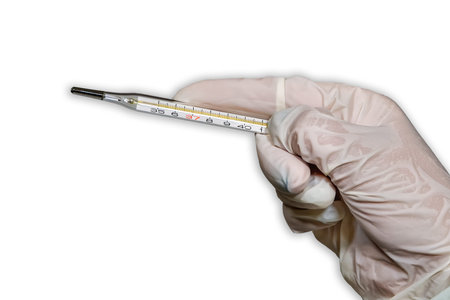 Flu concept with hand with protective glove holds thermometer against white background. Female...