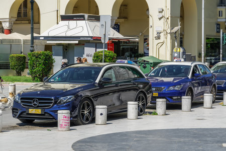 Thessaloniki, Greece taxis without passengers at the city center. Blue and white taxis with drivers, parked at taxi stop, in Aristotelous square.のeditorial素材