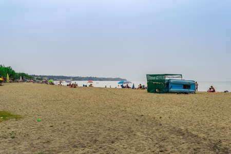 Neoi Epivates, Greece Public beaches open for the summer season. Bathers with sun umbrellas on sand by the sea at Thessaloniki suburbs, after government suggests people keep a distance.のeditorial素材