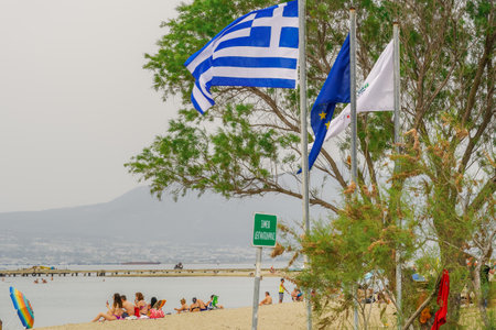 Neoi Epivates, Greece Public beaches open for the summer season. Bathers with sun umbrellas on sand by the sea at Thessaloniki suburbs, after government suggests people keep a distance.のeditorial素材