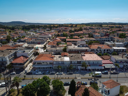 Chalkidiki, Greece coastal village landscape drone shot with low road traffic. Aerial day view of Kallithea at Kassandra peninsula with low rise buildings with red tiled roofs.のeditorial素材