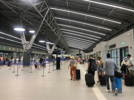 Thessaloniki, Greece - August 14 2020: Passengers with covid-19 protection masks at SKG airport check-in gates. People with face protection at new terminal of International Airport Macedonia.のeditorial素材