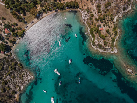 Mediterranean Greek landscape coastal drone shot with moored leisure boats. Aerial day top view of...