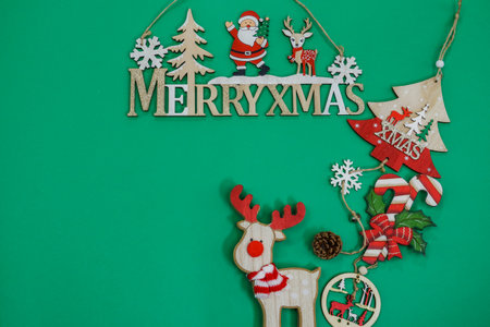 Advent Feast festive Christmas decorations flat lay with text copy space. Top view of overhead seasonal colorful composition figures on green background, with Merry Xmas sign.の写真素材
