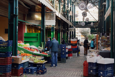 Thessaloniki, Greece - March 13 2021: People at greengrocer shop with masks. Food store with unidentified crowd wearing protective masks at enclosed market in the city center.のeditorial素材