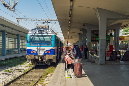 Thessaloniki, Greece - April 09 2021: Unidentified couple saying goodbye at a train station. Day view of passengers waiting to board a coach stopped on a station rail track platform.のeditorial素材