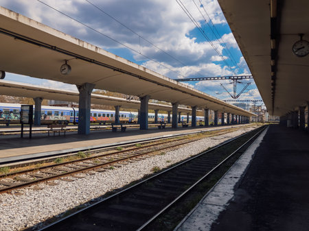 Thessaloniki, Greece - April 09 2021: Greek train wagons operated by OSE stopped at a train station. Empty coaches at a rail track platform without passengers.のeditorial素材