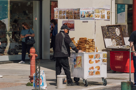 Thessaloniki, Greece - April 26 2021: Greek round sesame bagel street sale. Outdoors vendor on stand selling traditional crispy baked Koulouri Thessalonikis.のeditorial素材