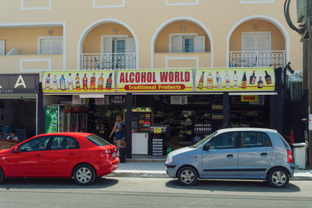 Zakynthos, Greece - July 9 2021: Exterior day view of alcohol shop with big overhead signs. Facade of liquor store with price tags on the Laganas village main road at the Ionian islands.のeditorial素材