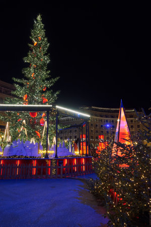 Thessaloniki, Greece - December 9 2021: Decorated and illuminated Christmas tree at Aristotelous square. Night view of festive installments at southern part of main city square, without crowd.のeditorial素材