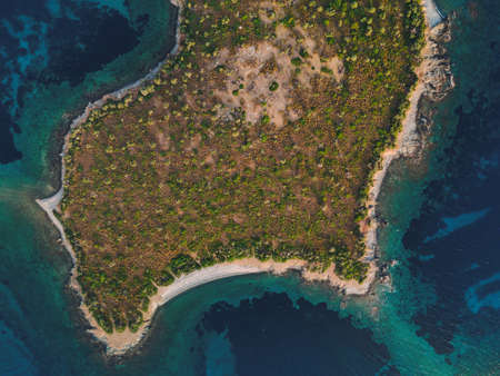 Day drone view above small island with green vegetation and rocky coastline in the Mediterranean at Chalkidiki peninsula, Greeceの写真素材