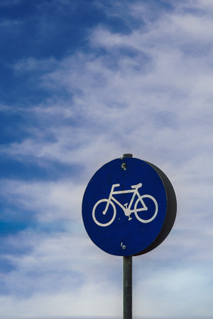 Low-rise day view of bikeway sign under blue sky with clouds.の写真素材