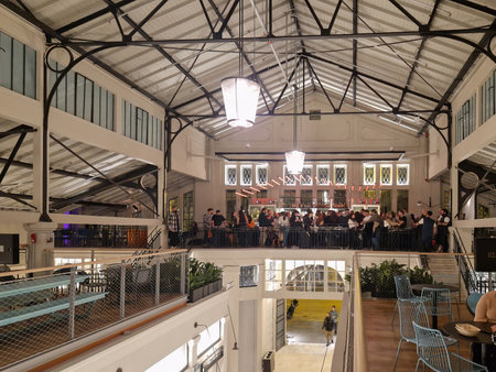 Thessaloniki, Greece - December 9 2022: renovated Modiano enclosed traditional food market. High-angle view of bar with crowd above food stalls at night.のeditorial素材