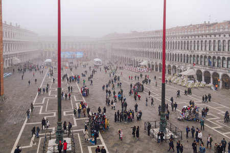 Venice Italy - February 22 2019: elevated day view of tourists on Saint Mark main square, around famous cafe bistro outdoor seating area with rows of chairs and tables.のeditorial素材