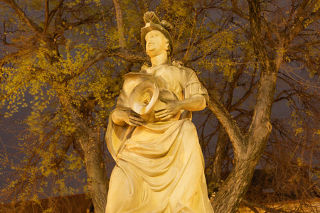 Woman with a vase statue at night near the main square of the Old Town in Bratislava, Slovakia.のeditorial素材