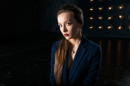 Studio portrait of a businesswoman in suit, against dark background