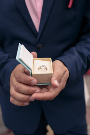 male hands holding a box with a wedding golden ring