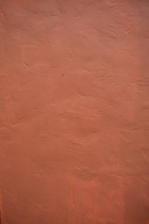 A stone texture wall in pink-brown paint.