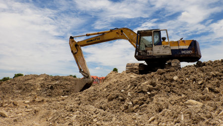 Nonthaburi, Thailand  September 13, 2015  The Komatsu Yellow backhoe in sandpile under blue sky