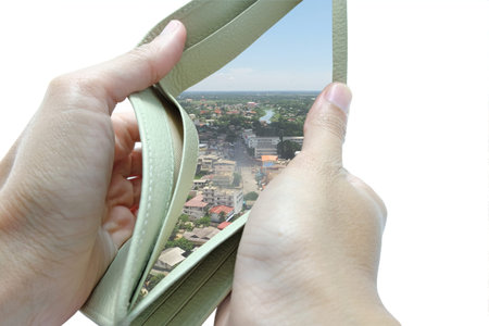 The wallet is opened by both hand in white background and found many buildings and houses
