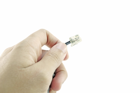 Isolated telephone cable plug held in handの写真素材