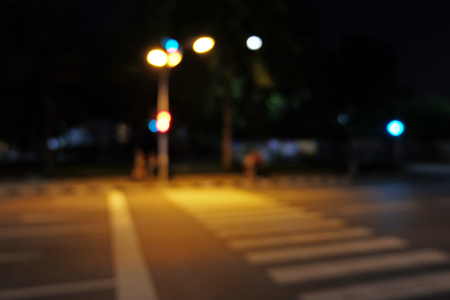 Light signal with mast at Roadside with crosswalk in the night in mode blurの写真素材