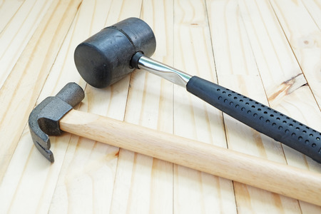 Tip of rubber hammer and steel hammer on wood floorの写真素材