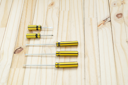 many sizes of yellow and black color screwdriver on wood floorの写真素材