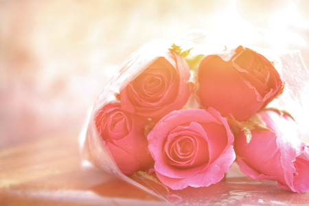 rose flowers pile which wrapped by transparent plastic on wood ground (Sweet colorful mode)の写真素材