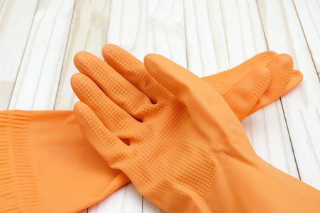 orange color rubber gloves on wood groundの写真素材