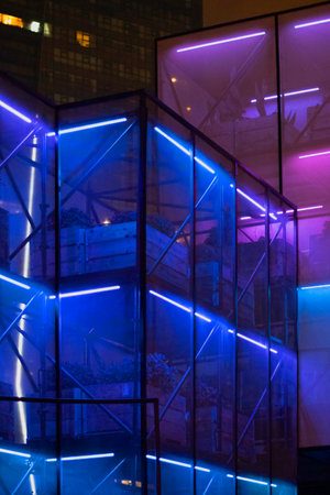 A futuristic glass greenhouse with plants, illuminated by neon lights, creating an enchanting and modern scene.の写真素材