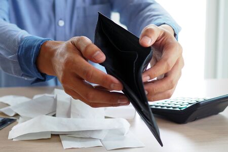 Man's hands open empty purse. Poverty, debt and bankruptcy in the payment of bills and credit cards. Broke conceptの写真素材