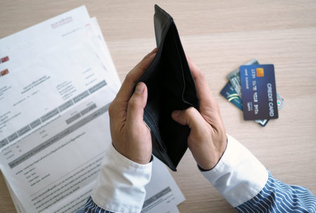 Hands open the empty purse. Invoices and credit cards awaiting payment. debt concept