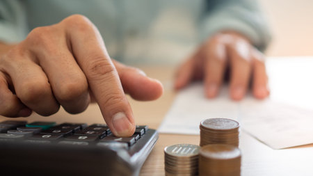 A close up of a business man using a calculator and financial planning. Calculation of expenses from...