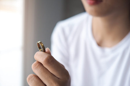 The wife holds the wedding ring after deciding to break up with her husband.