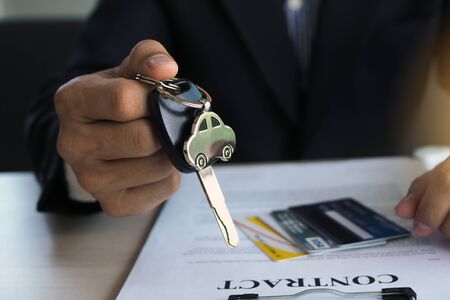 Agency sent the car keys to the owner after taking the car to make a mortgage contract to guarantee the loan.の写真素材