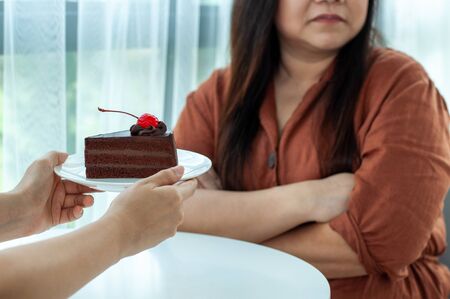 Fat women refuse to eat chocolate cakes. Intention to lose weight for good health and good shapeの写真素材