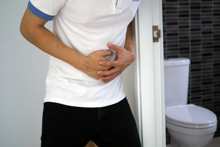 The man caught his stomach and had a painful stomach pain in the bathroom.