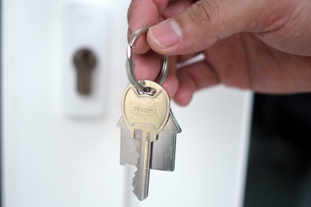 The hand of the banker holds the house key. Home and land mortgage concept