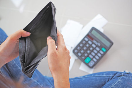 Woman hand holding empty wallet. Calculate the cost of credit card debt.