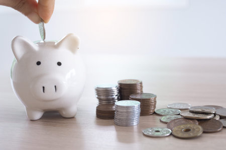 Hands are putting coins into the piggy bank. saving money concept