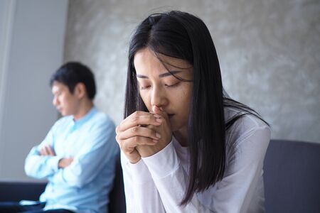 An Asian couple is stressed and upset after an argument.の写真素材