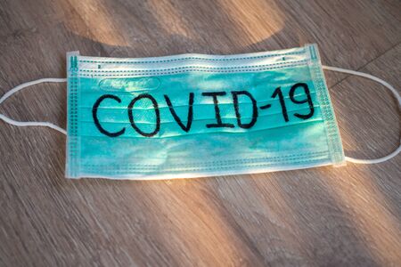 Mask write Covid-19 with natural light. The situation of the 2019-nCoV virus infection is spreading around the world. Deadly plague of the world. The concept wear a mask to protect coronavirusの写真素材
