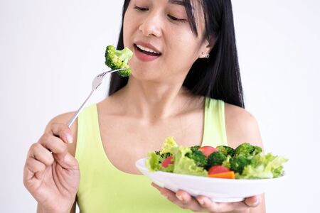 Asian beautiful women are happy to eat salad vegetables.の写真素材