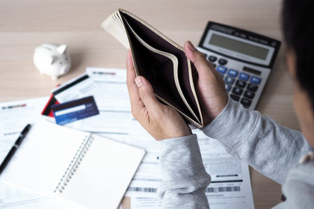 Hands open the empty purse after calculating the cost from the credit card and bill. debt concept