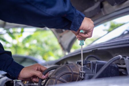 The engine engineer is checking and repairing the car. Off-site care servicesの写真素材
